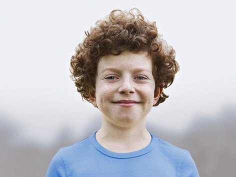 Teaser Foto allergisches Asthma, lächelnder Junge in der Natur, im direkten Blickkontakt