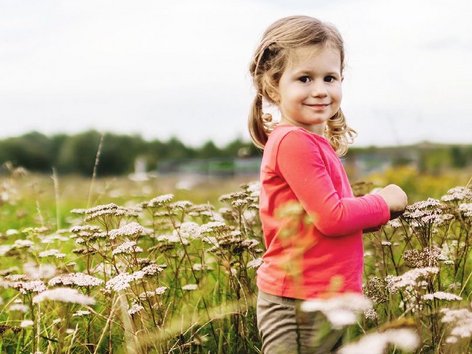 Teaser Foto Atopische Haut; fröhliches Mädchen auf einer Blumenwiese