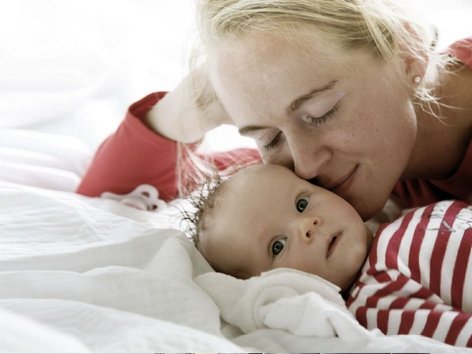 Teaser Foto Neurodermitis, Mutter liegt verträumt neben Baby 